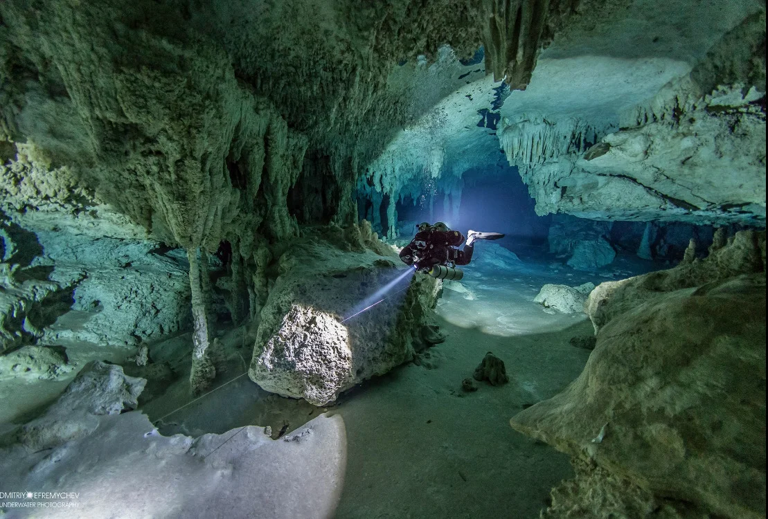 TDI Full Cave Diver student exploring underwater cave with guideline and light